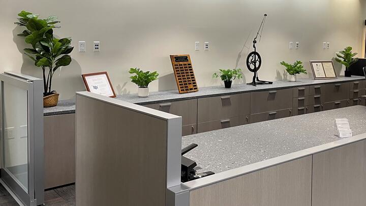 Part of the library's new front desk with plants and other items on the counters.